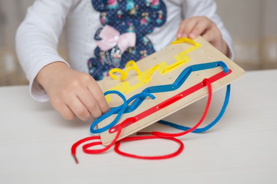 niño jugando con juguete didáctico de madera