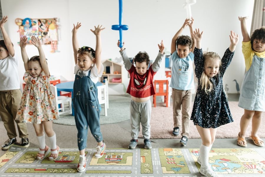 niños en el colegio con manos alzadas